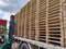 Worker driving forklift to loading and unloading wooden pallets from truck to warehouse cargo storage, shipment in logistics and