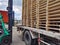 Worker driving forklift to loading and unloading wooden pallets from truck to warehouse cargo storage, shipment in logistics and