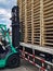 Worker driving forklift to loading and unloading wooden pallets from truck to warehouse cargo storage, shipment in logistics and