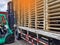 Worker driving forklift to loading and unloading wooden pallets from truck to warehouse cargo storage, shipment in logistics