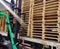 Worker driving forklift truck to unload wooden pallets stack from truck to the cargo warehouse to support shipment for logistics a