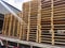 Worker driving forklift truck to unload wooden pallets stack from truck to the cargo warehouse to support shipment for logistics a