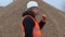 Worker eating hamburger at the pile of crushed stone