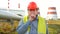 Worker, engineer, or electrician looking at the camera making silence gesture standing in front of a power station