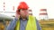 Worker, engineer, or electrician looking directly at the camera eavesdropping in front of a power station