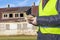 Worker with euro banknotes near abandoned house