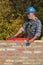 Worker examining brick wall using level tool