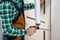 Worker fills the seam between the door frame and the wall with polyurethane foam, close-up