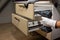 Worker fix over tight drawer slides in kitchen. Concept Fix stuck wooden drawer slides