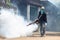 Worker fogging chemical to eliminate mosquito at the street