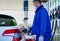 A worker at the gas station refueling the gas stock image