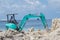 Worker gather sand with excavator at construction site