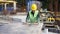 Worker in goggles sawing a board on a circular saw.