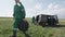 Worker in Green Carries Bobbin with Wire on Field