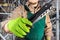 Worker in green overall outfit with riveter tool