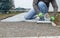 Worker hammering the stone plates to install footpath