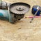 Worker hand holding angle grinder with diamond cutting disc for concrete ready to saw a cement slab. Space for text