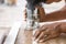 Worker hands cutting the edge of wood board using fret saw