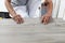 Worker hands installing timber laminate vinyl floor. Wooden floors house renovation