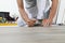 Worker hands installing timber laminate vinyl floor. Wooden floors house renovation