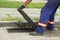 Worker hands opens a drain grate close-up