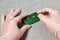 Worker hands with tweezers repairing the pcb with a small microchip