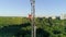 Worker in hard hat climbs high on radio telecommunication tower on background beautiful city landscape, aerial view of