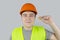 A worker in a hard hat and green vest puts on ear plugs. Industrial safety. Industrial noise protection. Compliance with the rules