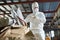 Worker in Hazmat Suit Sorting Cardboard at Recycling Plant