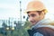 Worker in a helmet against the background of a substation