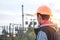 Worker in a helmet against the background of a substation