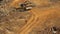 Worker in the helmet goes on a dirt road indicating the way the bulldozer