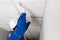 A worker in a helmet is installing a suspended ceiling, rear view