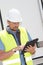 worker with helmet near a industrial wall back truck, checking tablet stage of the project