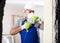 Worker in helmet is perforating wall with drill