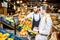 Worker helping woman to weigh fruits in the supermarket