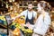 Worker helping woman to weigh fruits in the supermarket