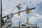 Worker high up  in crane basket repairing traffice lights at intersection with building in background