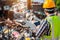 A worker holding a tablet looks at a pile of steel for recycling at a recycling plant. Recycle waste