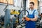 Worker holds bicycle wheel near machine tool