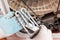 A worker holds a broken heating element of a washing machine, covered with scale. Hands and spare part close-up. Repair