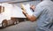 Worker Holds a Clipboard Controlling the Loading of Cargo into Shipping containers. Trucks Parked Loading at Dock Warehouse.