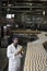 Worker inspecting orange juice bottle at bottling plant