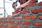 Worker is installing the bricklayer of the wall