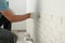 Worker installing decorative wall tiles in room, closeup