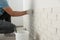 Worker installing decorative wall tiles in room, closeup