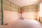 A worker is installing a roll of insulation in the construction of a country house