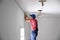 Worker installing stretch ceiling in  room