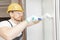 Worker in installing white plastic upvc window on house