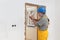 Worker installing wooden door, using polyurethane foam